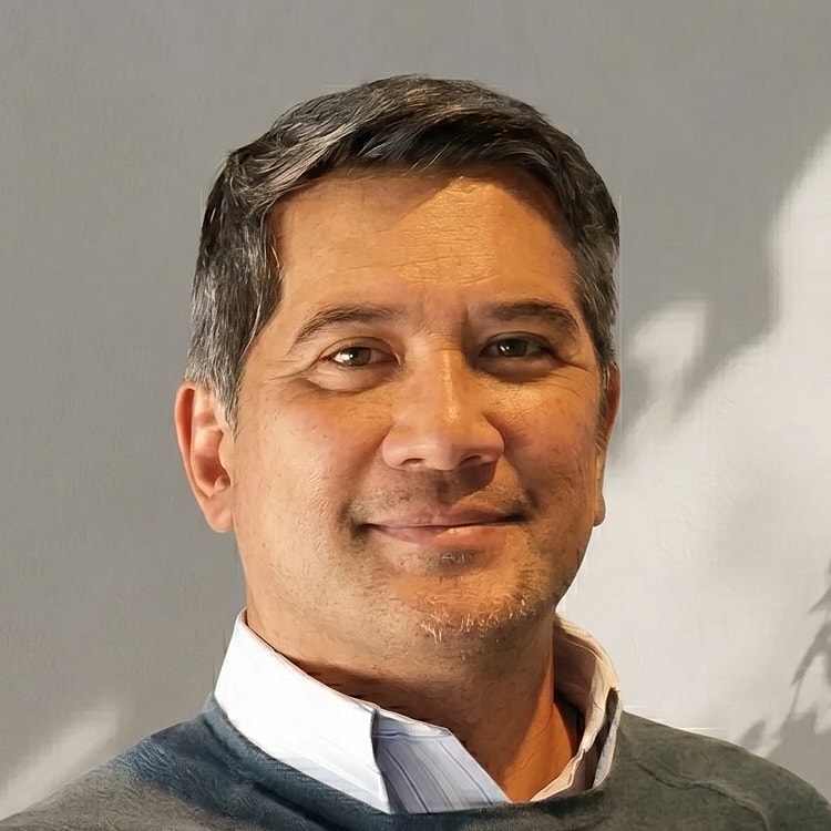 Man smiling against a plain background.