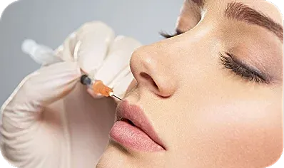 Cosmetic procedure with syringe near lips.