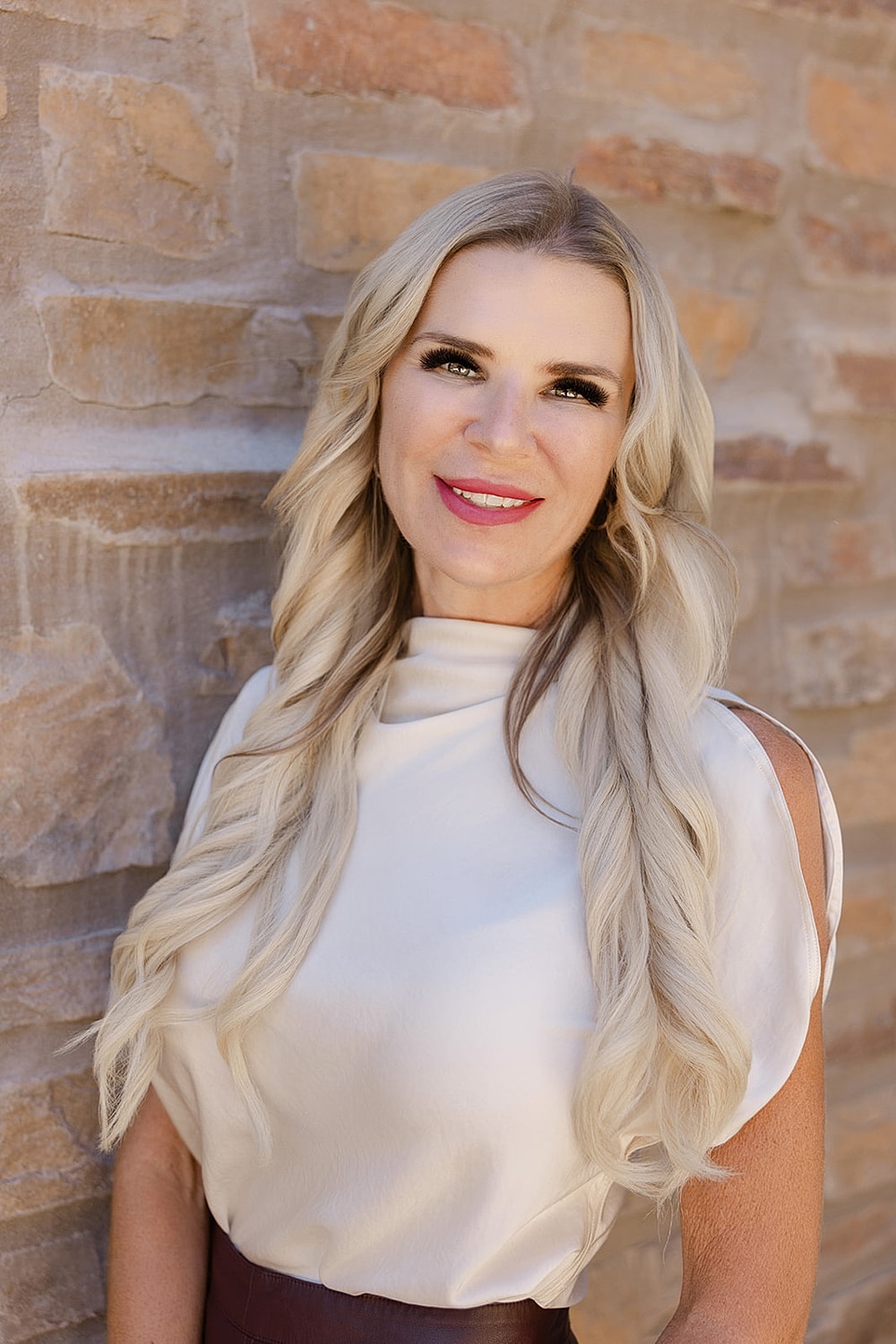 Smiling woman with long blonde hair.