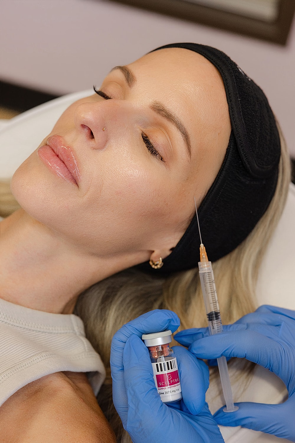 Woman undergoing aesthetic treatment with syringe.